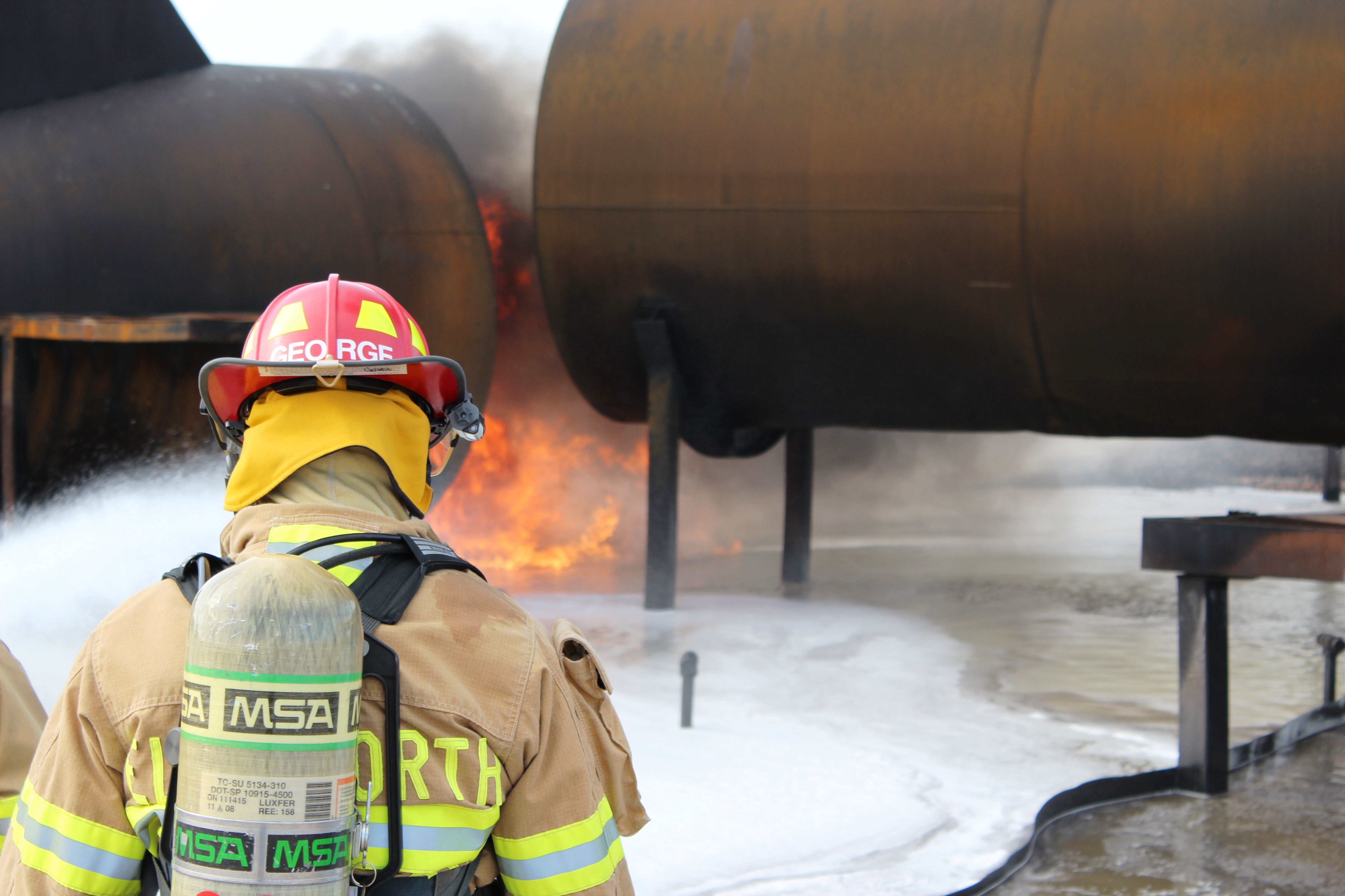 Firefighters putting out a fire at an aircraft firefighting training site